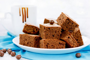 Delicious chocolate brownies with hot chocolate in a cup