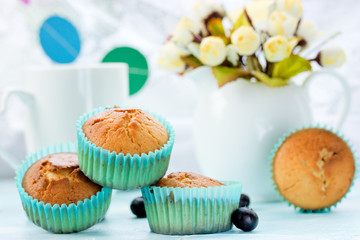 Delicious muffins on the festive table with a bouquet of flowers