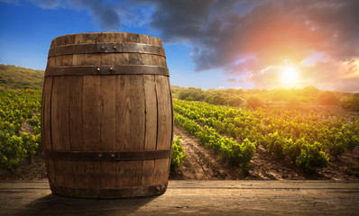 Red wine with barrel on vineyard in green Tuscany, Italy