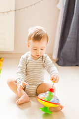 baby boy playing with toy indoors at home