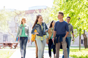 group of happy teenage students walking outdoors