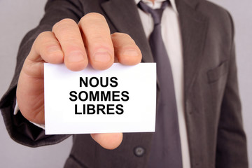 Homme tenant une carte avec nous sommes libres &eacute;crit dessus