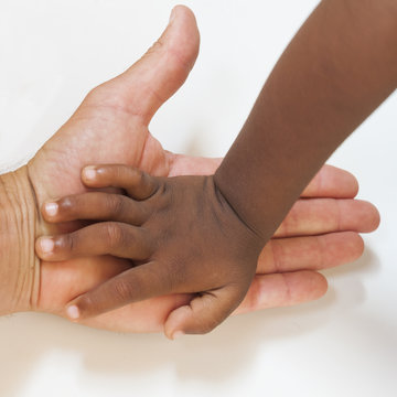 main noire d'enfant dans main blanche adulte