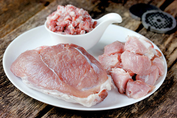 Raw pork meat assortment on a white plate