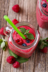 Top view on detox berry smoothie in glass jar with mint.