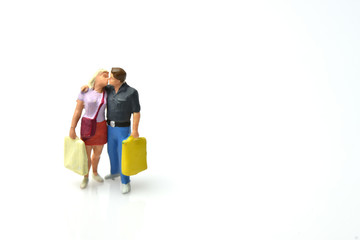 miniature people : the lover and shopping bag kissing on white background