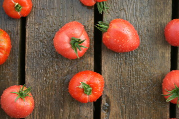 Урожай красных спелых томатов на деревянном фоне
