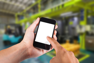 Person using smartphone white screen holder on hand with blurry background of industrial factory.