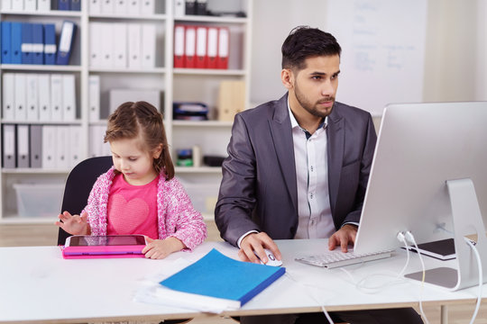 papa arbeitet im büro am computer, kind spielt am tablet