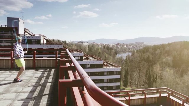 A man exercises with a jumping rope on the roof
