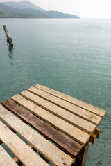 Fototapeta premium Wooden slat walkway on sky blue water background