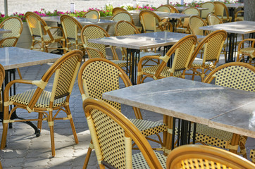 empty street cafe interior in city, tables and chairs, ornate with flowers, summer season, without people