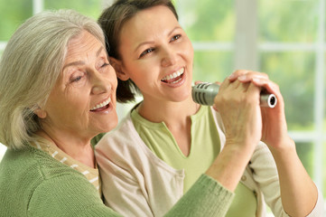 Senior woman with daughter  singing on microphone 
