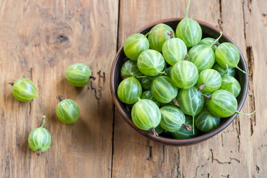 Fresh green gooseberries in bowl on table close-up