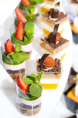 mini canapes in plastic cups decorated with edible flowers