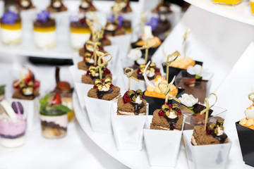 mini canapes in plastic cups decorated with edible flowers