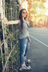 Urban vintage portrait of beautiful and attractive girl with sunglasses. Warm summer colors and haze. Strong backlight.