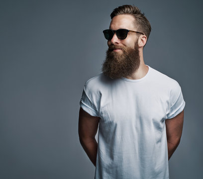 Bearded handsome man with sunglasses looking over