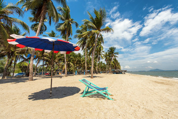 Beach chairs on the white sand under coconut tree beach with clo