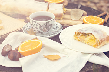 Strudel with custard and orange. Autumn table decoration.