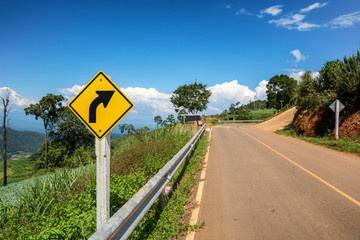 yellow sign on the road with clear sky at the way to pai , chian