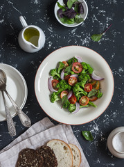 Fresh salad with broccoli and tomatoes on a dark background. Healthy vegetarian food