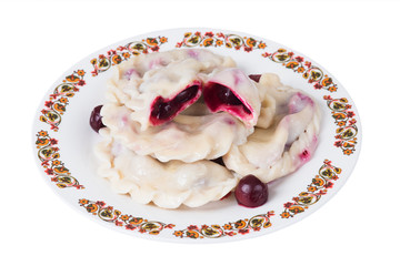 Ukrainian dumplings with cherries on plate, isolated