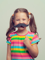 beautiful cute little girl playing with mustache