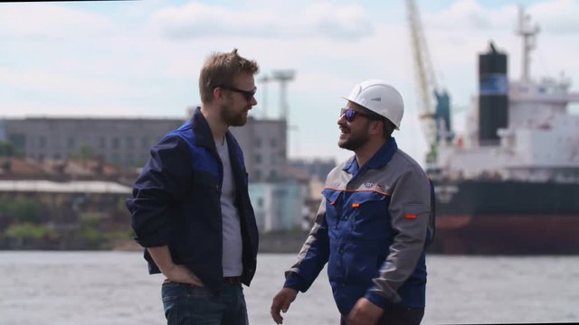Two good friends, dockers, coworkers and colleages give high five in Shipping cargo port