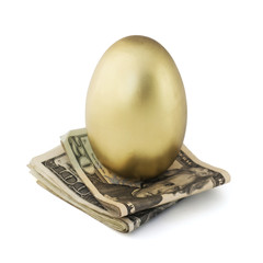 Gold egg balanced on U.S. currency. Balanced portfolio. © ImagePixel