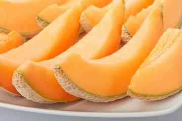 Cantaloupe melon, orange slices on dish