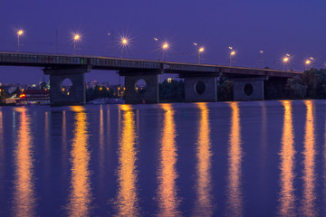 Night bridge lights reflected in river waters. HDR