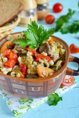 Vegetable stew with meat and barley on a blue background