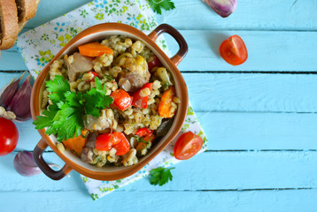 Vegetable stew with meat and barley on a blue background