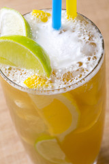 Close-up ice tea with cream, ice, yellow and green lemon