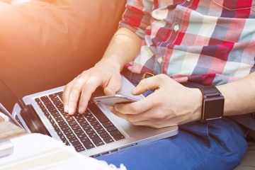 Cropped image of modern man with laptop, phone and watch