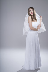 Fototapeta premium Happy sexy beautiful bride brunette girl in white wedding dress on white background