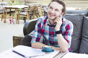 Happy man talking on the phone in cafe. Handsome stylish guy with phone.