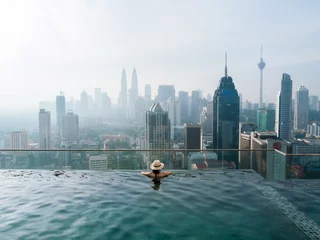 Foto auf Acrylglas Frau genießt die Aussicht von einem Infinity-Pool © Suzanne Plumette
