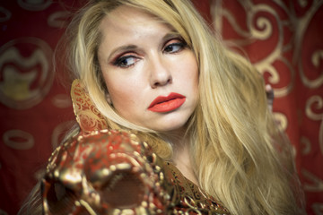 Sweet, blonde dressed in red armor gold on red art nouveau flour