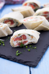 Roll from red fish with cheese and greens