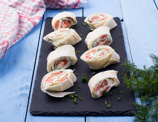 Roll from red fish with cheese and greens