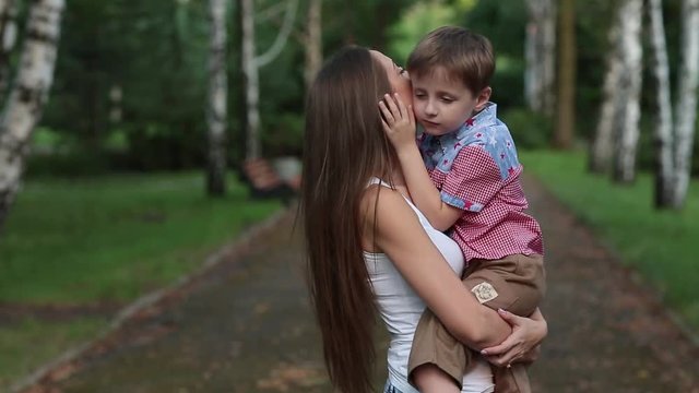 Woman Kisses and Hugs His Son in the Park