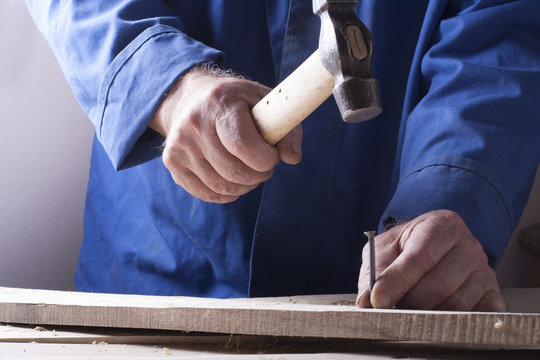 Carpenter working with plane on wooden background at Building Site. Joiner workplace