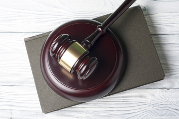 Law concept - Book with wooden judges gavel on table in a courtroom or enforcement office.