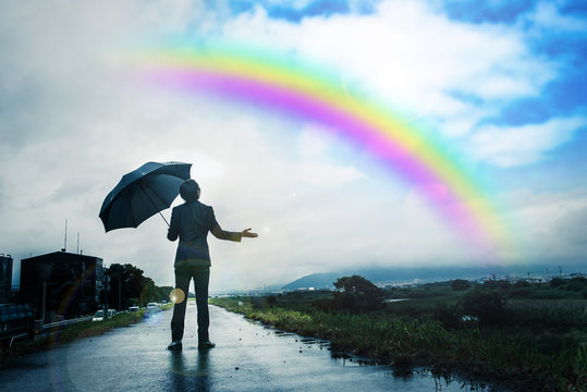 傘を差すビジネスマン 雨上がりの空と虹 Stock Photo Adobe Stock