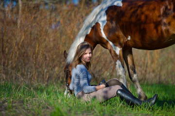 Girl sportswoman and her horse in the spring