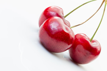 Three cherries on a white background