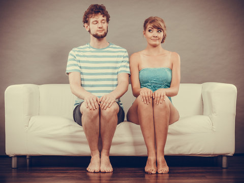 Shy Woman And Man Sitting Close To Each Other On Couch.