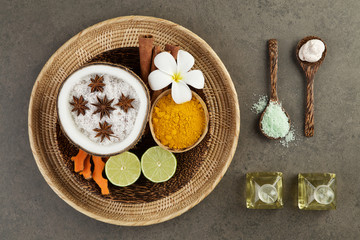 Fototapeta na wymiar Asian spa setting with coconut, turmeric, lime, cinnamon, anise,